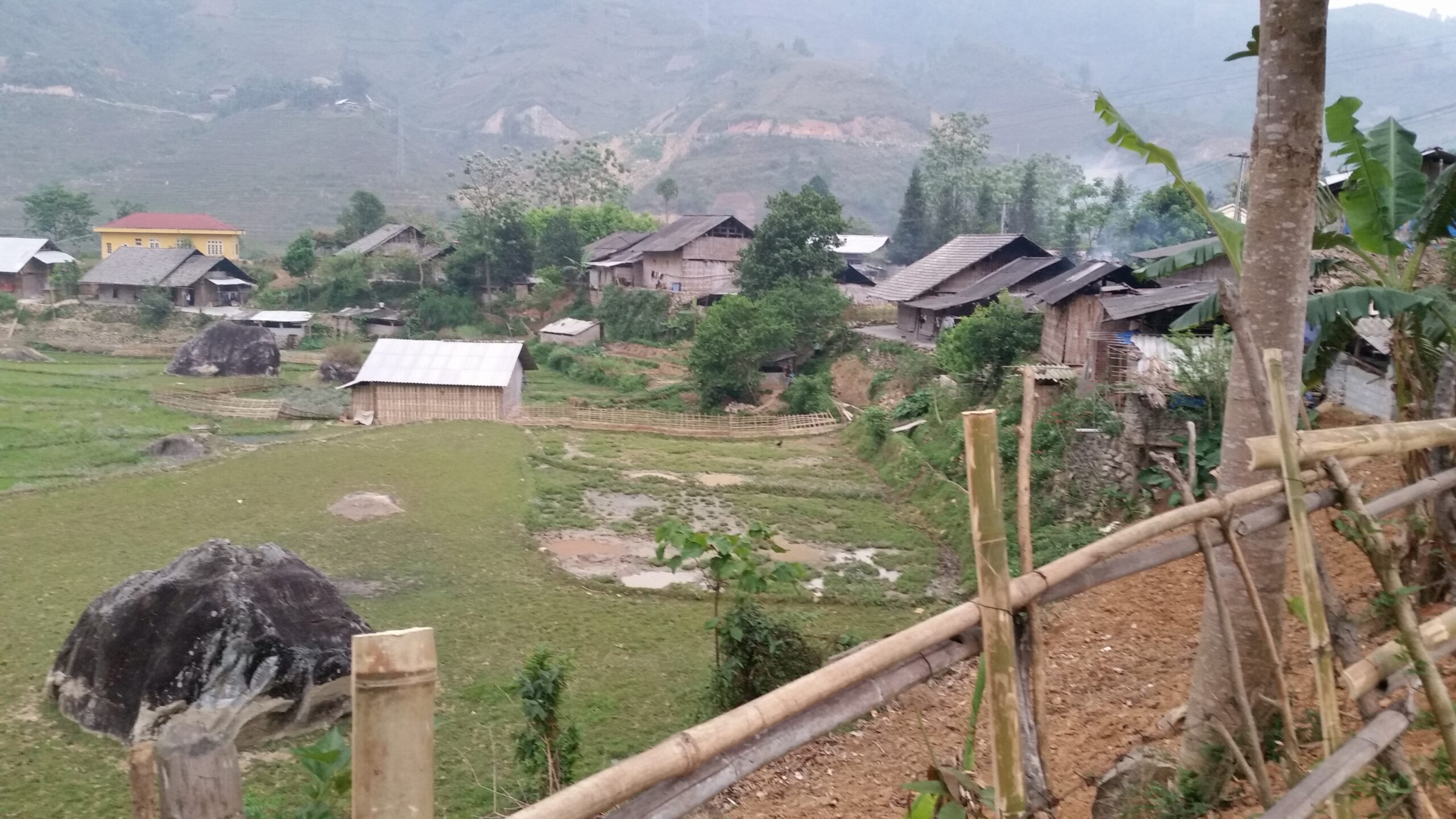 Rural village with wooden houses and fields.
