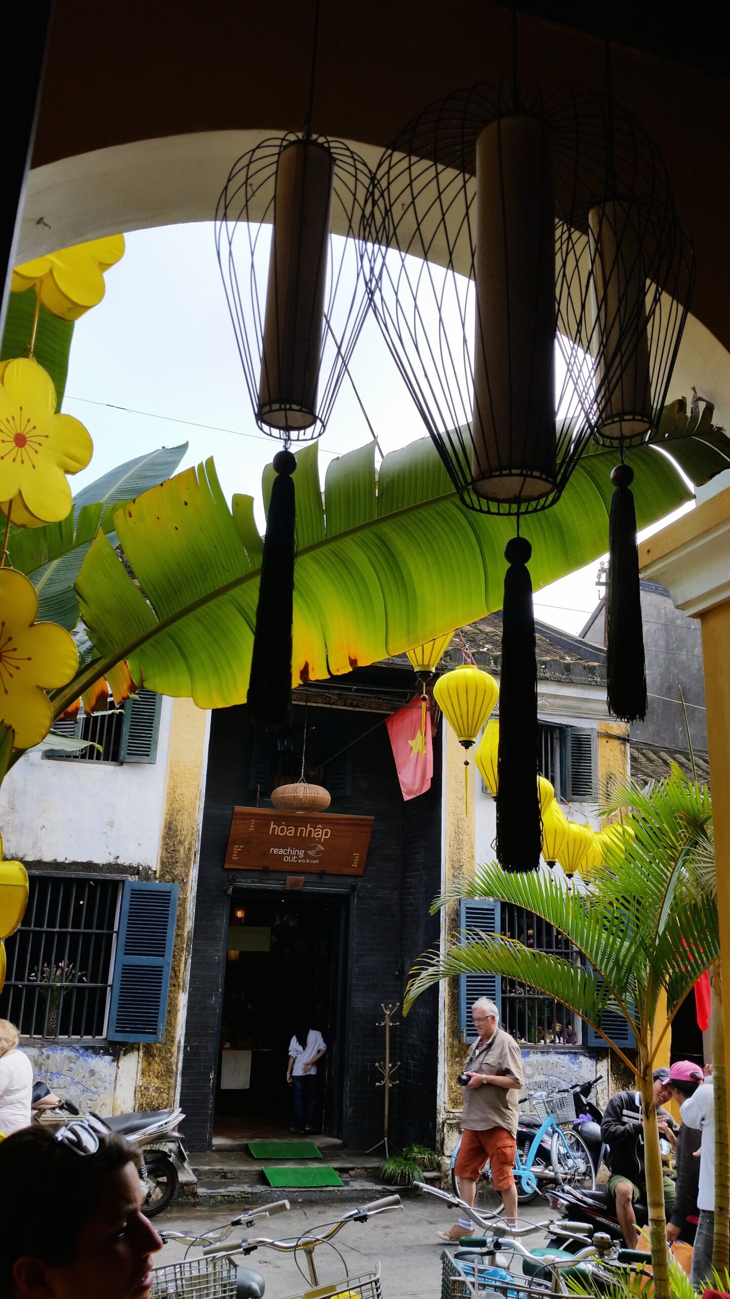 Outdoor scene with lanterns and yellow flowers.
