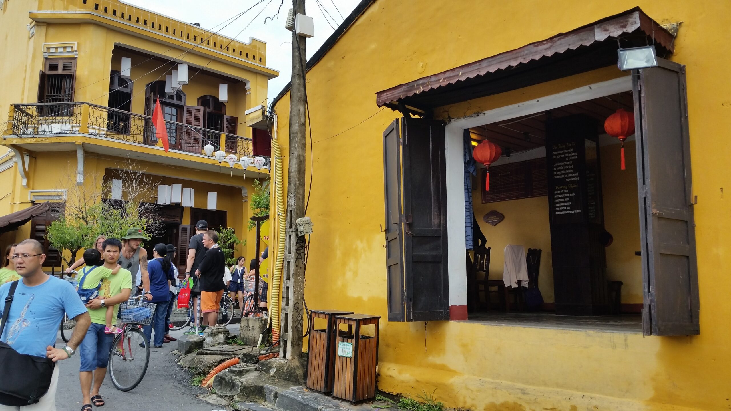 Yellow buildings and people in bustling street.
