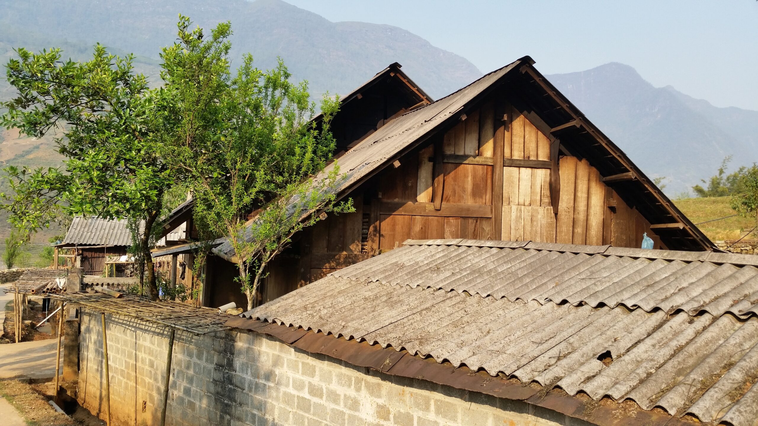 Rustic wooden house with mountain backdrop.