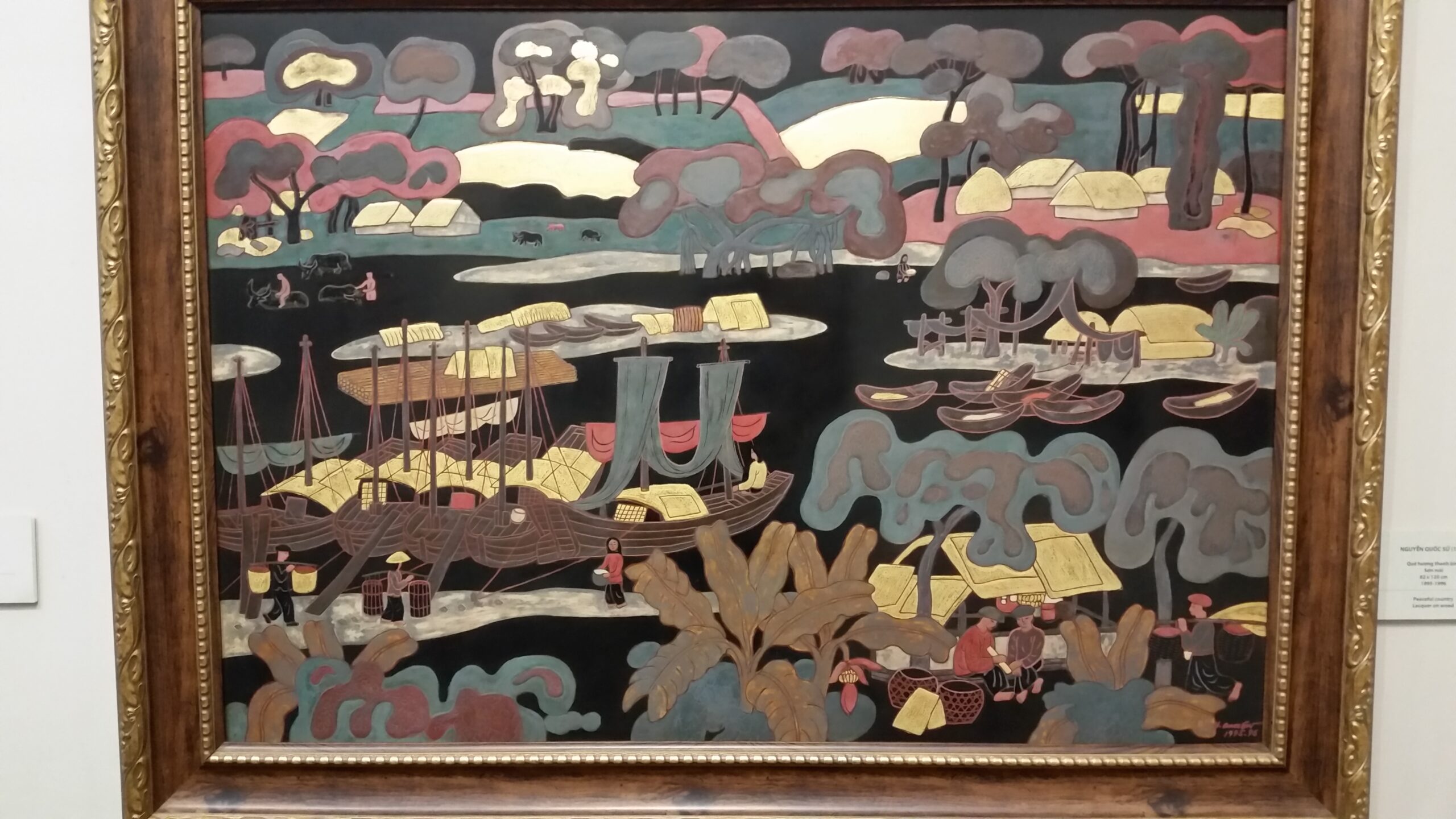 Framed painting depicting boats and landscape scene.