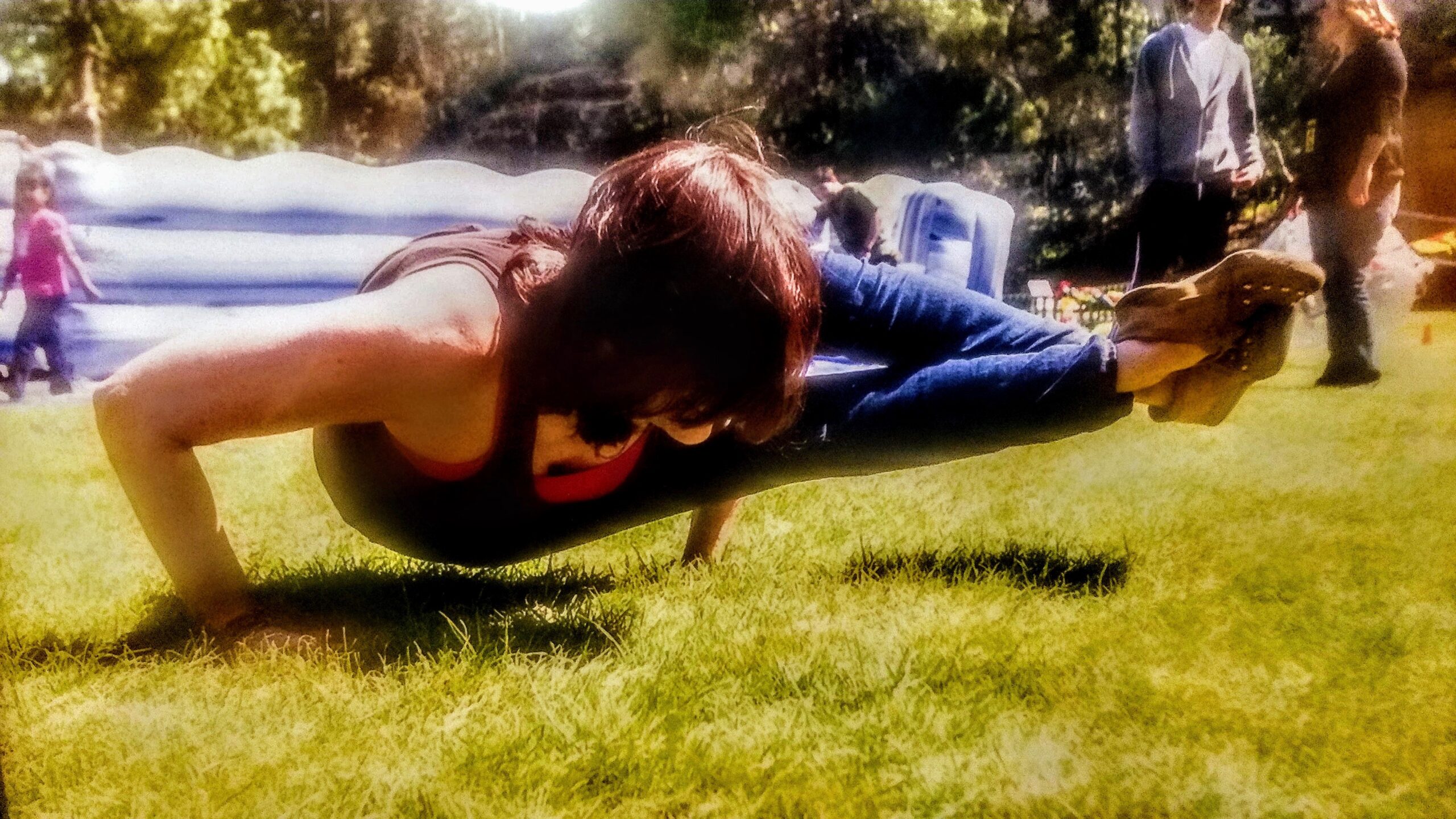 Person performing an advanced yoga pose outdoors.