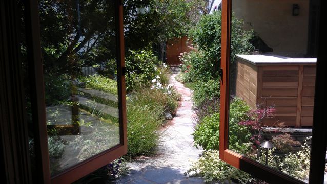 Garden path view through open doors.