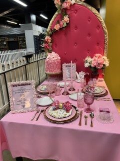 Elegant pink-themed table setting with cake.