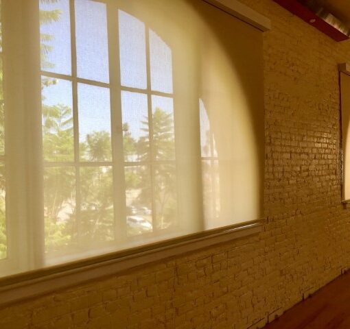 Bright room with large shaded windows.